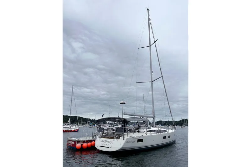  Yacht Photos Pics 2020 Jeanneau 54 sailboat docked in a marina under cloudy skies.