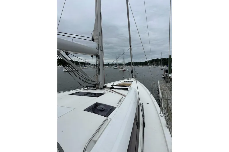  Yacht Photos Pics 2020 Jeanneau 54 sailboat docked in a marina under cloudy skies.