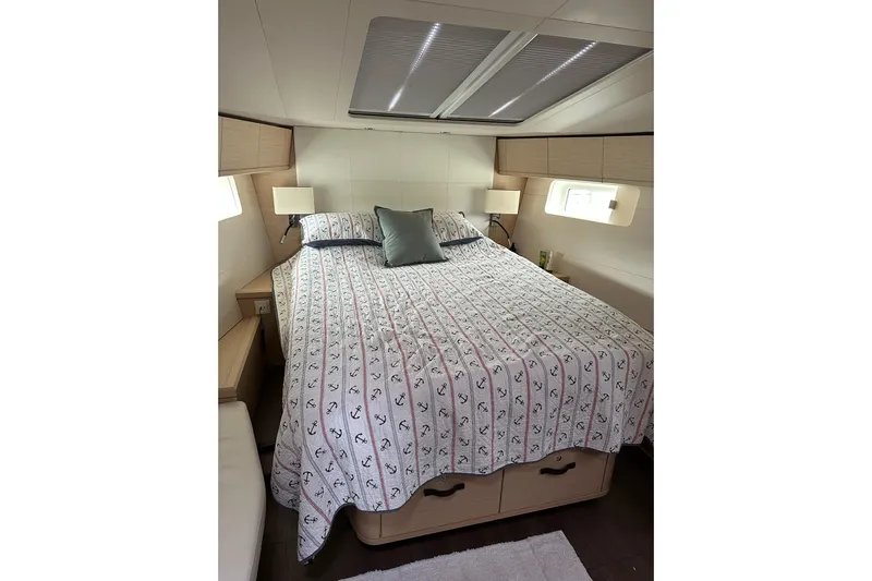  Yacht Photos Pics Luxurious bedroom interior of 2020 Jeanneau 54 yacht with nautical-themed bedding.