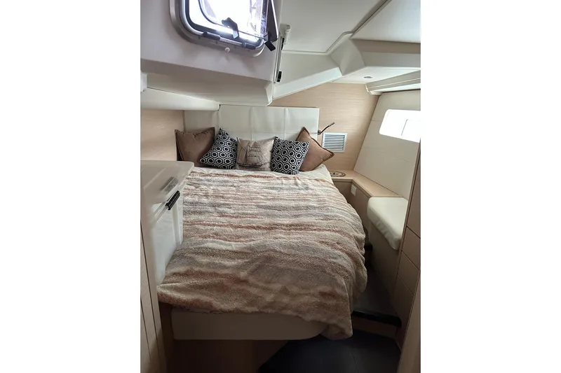  Yacht Photos Pics Cozy bedroom interior of 2020 Jeanneau 54 yacht with plush bedding and decorative pillows.
