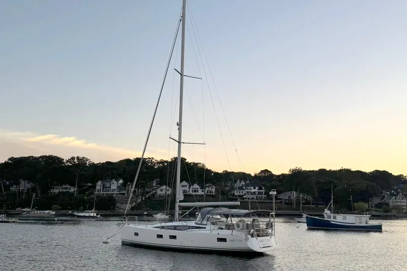 Yacht Photos Pics 2020 Jeanneau 54 sailboat anchored in a serene harbor at sunset.