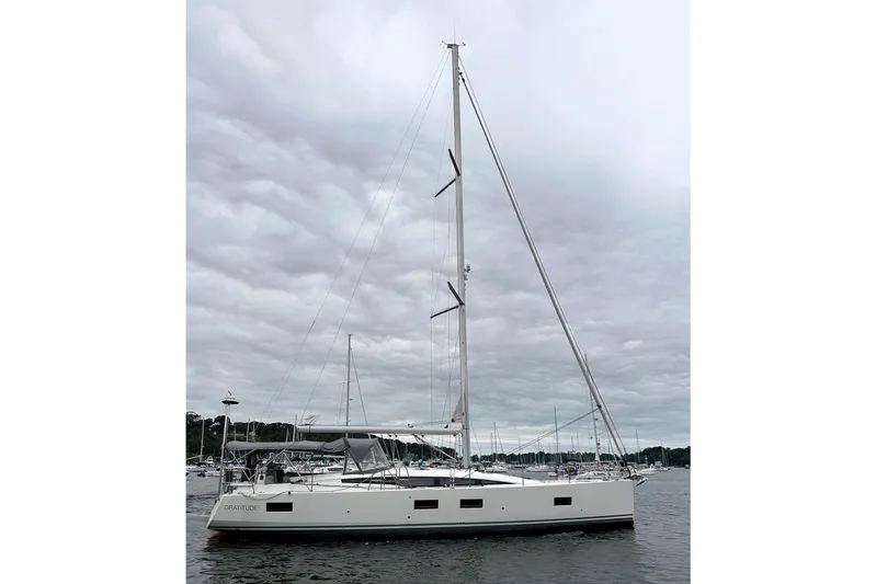  Yacht Photos Pics 2020 Jeanneau 54 sailboat on calm water under cloudy sky.