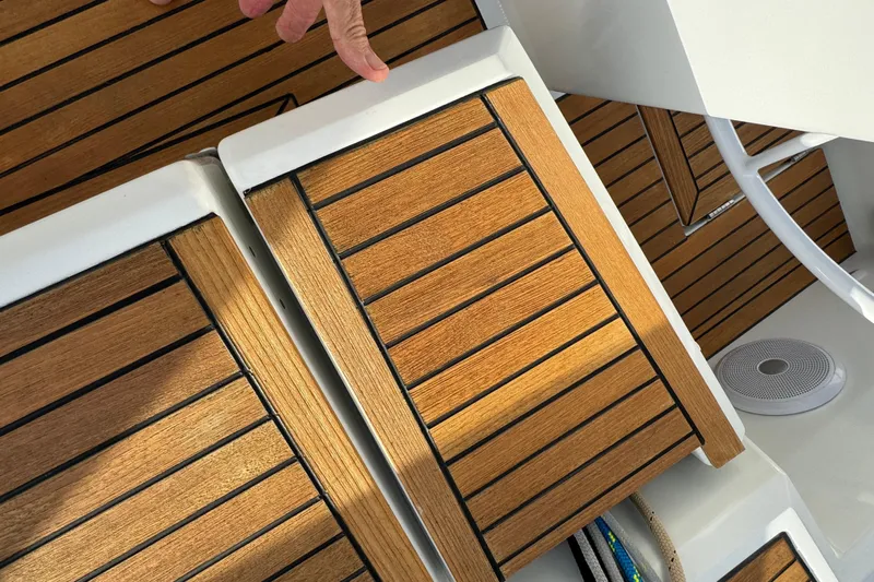  Yacht Photos Pics Teak deck of 2023 Beneteau Oceanis 46.1 yacht with hand and speaker visible.