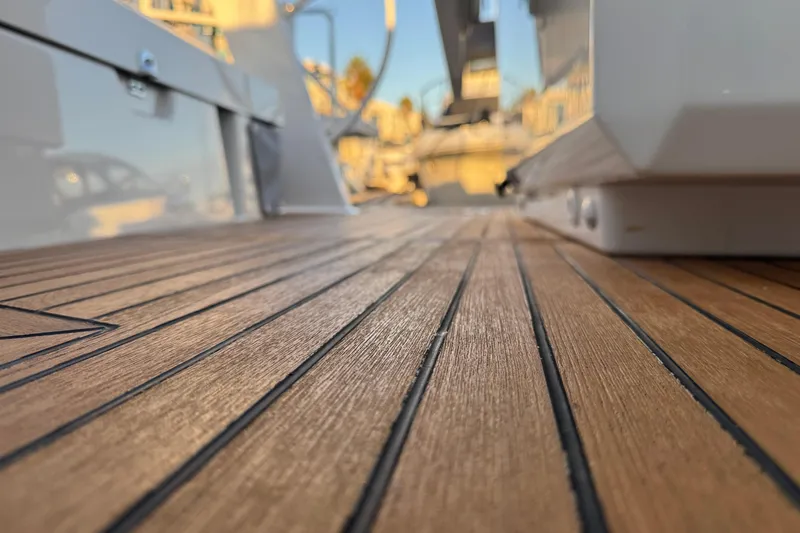  Yacht Photos Pics Close-up of 2023 Beneteau Oceanis 46.1 teak deck, showcasing elegant wood grain detail.