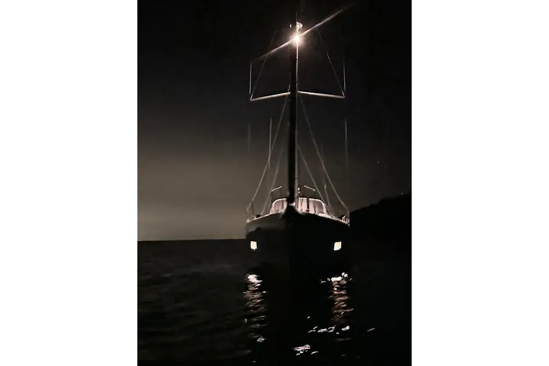  Yacht Photos Pics Night view of 2023 Beneteau Oceanis 46.1 sailboat illuminated on calm water.