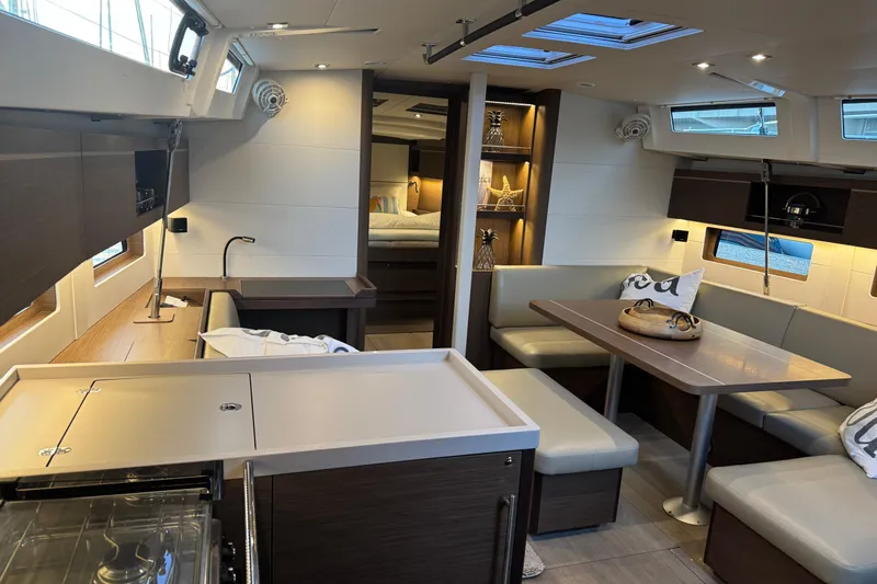  Yacht Photos Pics Modern interior of 2023 Beneteau Oceanis 46.1 yacht with sleek kitchen and cozy seating area.