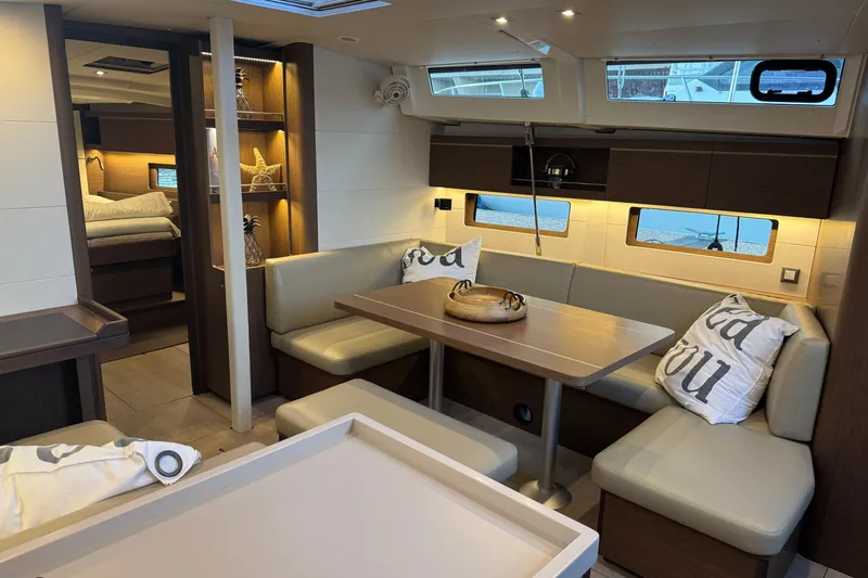  Yacht Photos Pics Luxurious interior of 2023 Beneteau Oceanis 46.1 yacht with modern dining area and cozy seating.