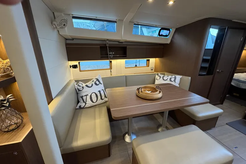  Yacht Photos Pics Interior of 2023 Beneteau Oceanis 46.1 yacht with cozy dining area and nautical decor.