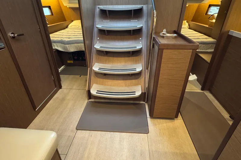  Yacht Photos Pics Interior of 2023 Beneteau Oceanis 46.1 yacht, featuring wooden stairs and cozy cabins.