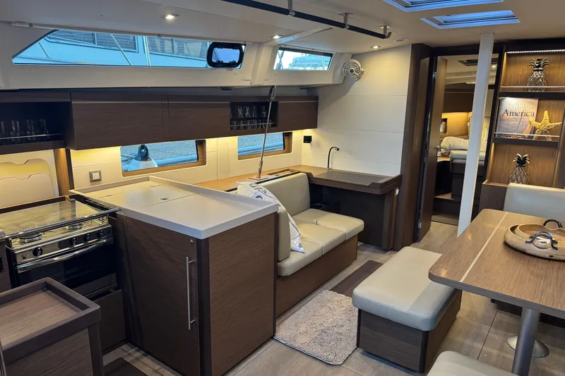  Yacht Photos Pics Luxurious interior of 2023 Beneteau Oceanis 46.1 yacht, featuring modern kitchen and cozy seating area.