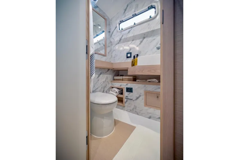 Oasis Yacht Photos Pics Luxurious bathroom in 2022 Tesoro T40 Inboard yacht with marble walls and modern fixtures.
