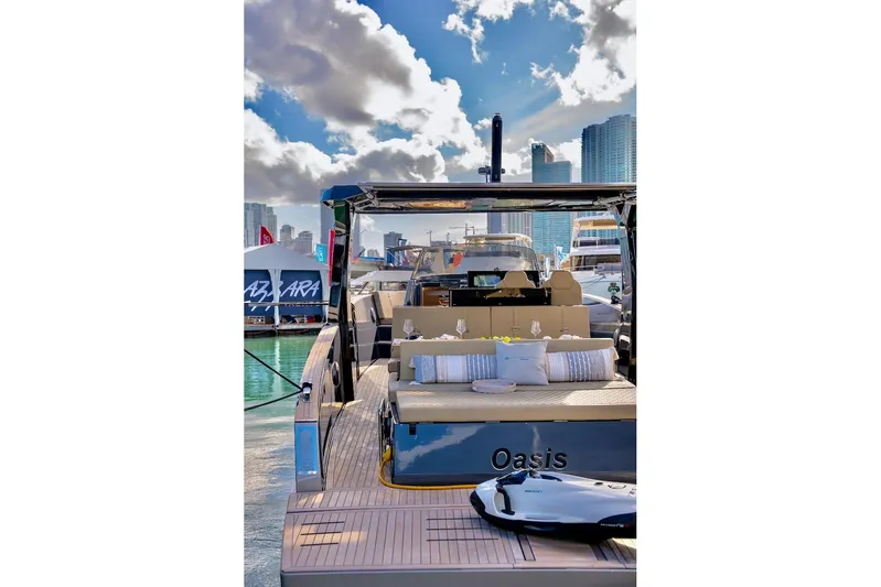 Oasis Yacht Photos Pics 2022 Tesoro T40 Inboard yacht docked, featuring luxurious seating and city skyline backdrop.