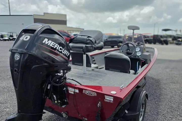 2020 Tracker Pro 160 boat with Mercury engine, red exterior, parked outdoors.