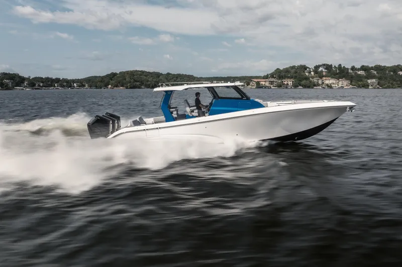  Yacht Photos Pics 2026 Fountain 43 SCX speedboat cruising on a lake with scenic shoreline background.