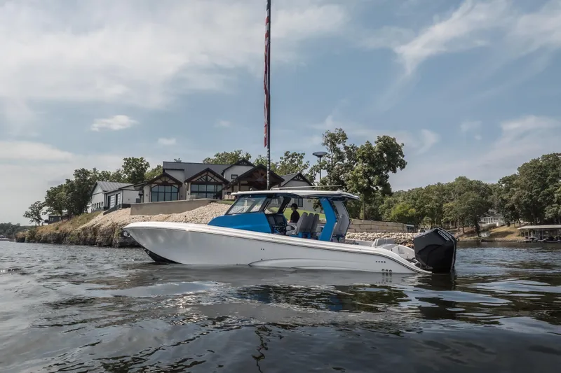  Yacht Photos Pics 2026 Fountain 43 SCX boat on a scenic lake near modern waterfront homes.