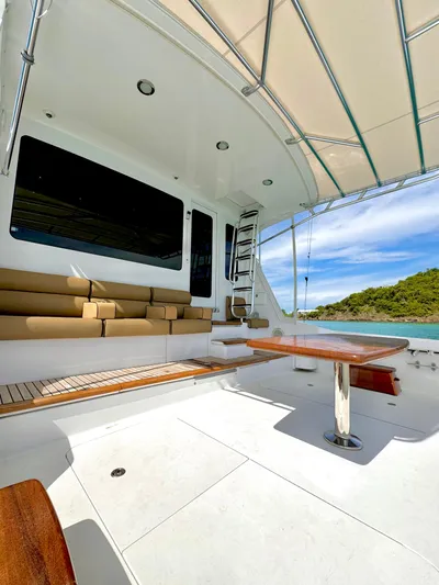 Red Queen Yacht Photos Pics 2008 Hatteras Enclosed Bridge yacht with spacious deck and seating, docked by scenic waters.