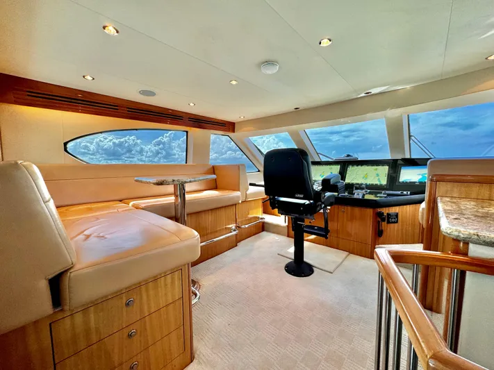 Red Queen Yacht Photos Pics Luxurious 2008 Hatteras Enclosed Bridge interior with plush seating and panoramic windows.