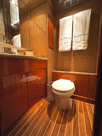Red Queen Yacht Photos Pics Luxurious 2008 Hatteras Enclosed Bridge yacht bathroom with wood flooring and elegant fixtures.