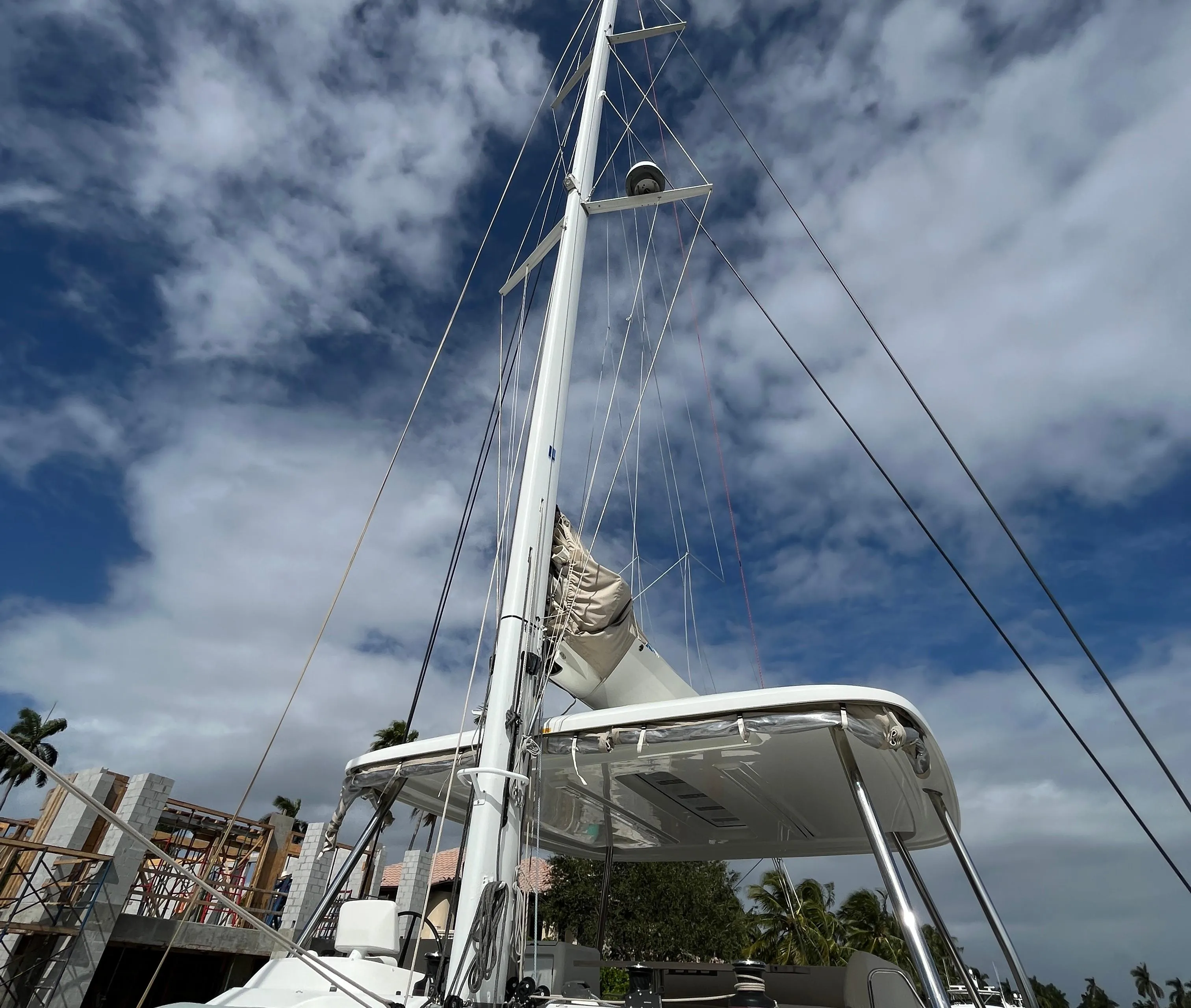 Lagoon 55 catamaran, 2021 model, with sails against a partly cloudy sky.