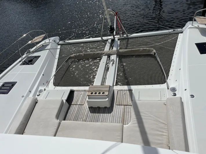  Yacht Photos Pics Lagoon 55 catamaran deck, 2021 model, featuring spacious seating and netting over water.