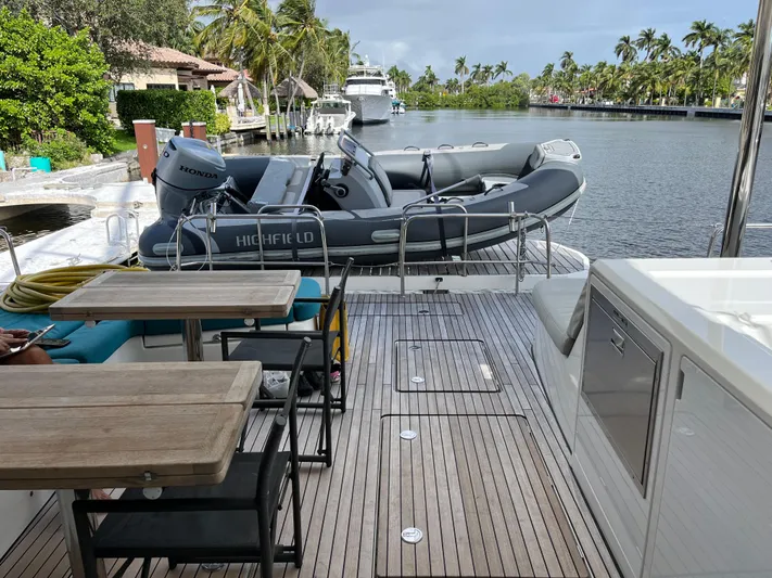 Yacht Photos Pics Lagoon 55 yacht deck with dining area and inflatable boat, 2021 model.