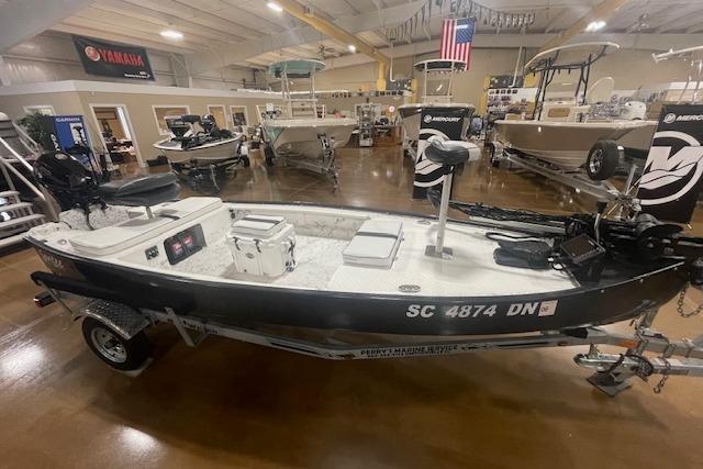 2020 Santee 160TS boat in showroom, featuring motor and equipment, with American flag in background.