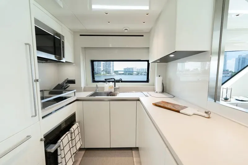 Yacht Photos Pics Modern kitchen interior on 2021 Sanlorenzo SX76 yacht, featuring sleek white cabinetry and appliances.