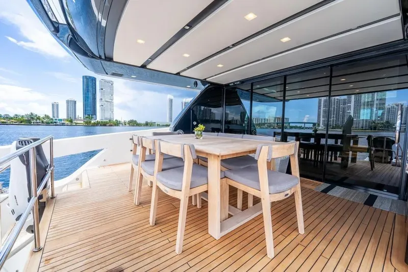  Yacht Photos Pics Luxurious 2021 Sanlorenzo SX76 yacht deck with dining area, city skyline view.