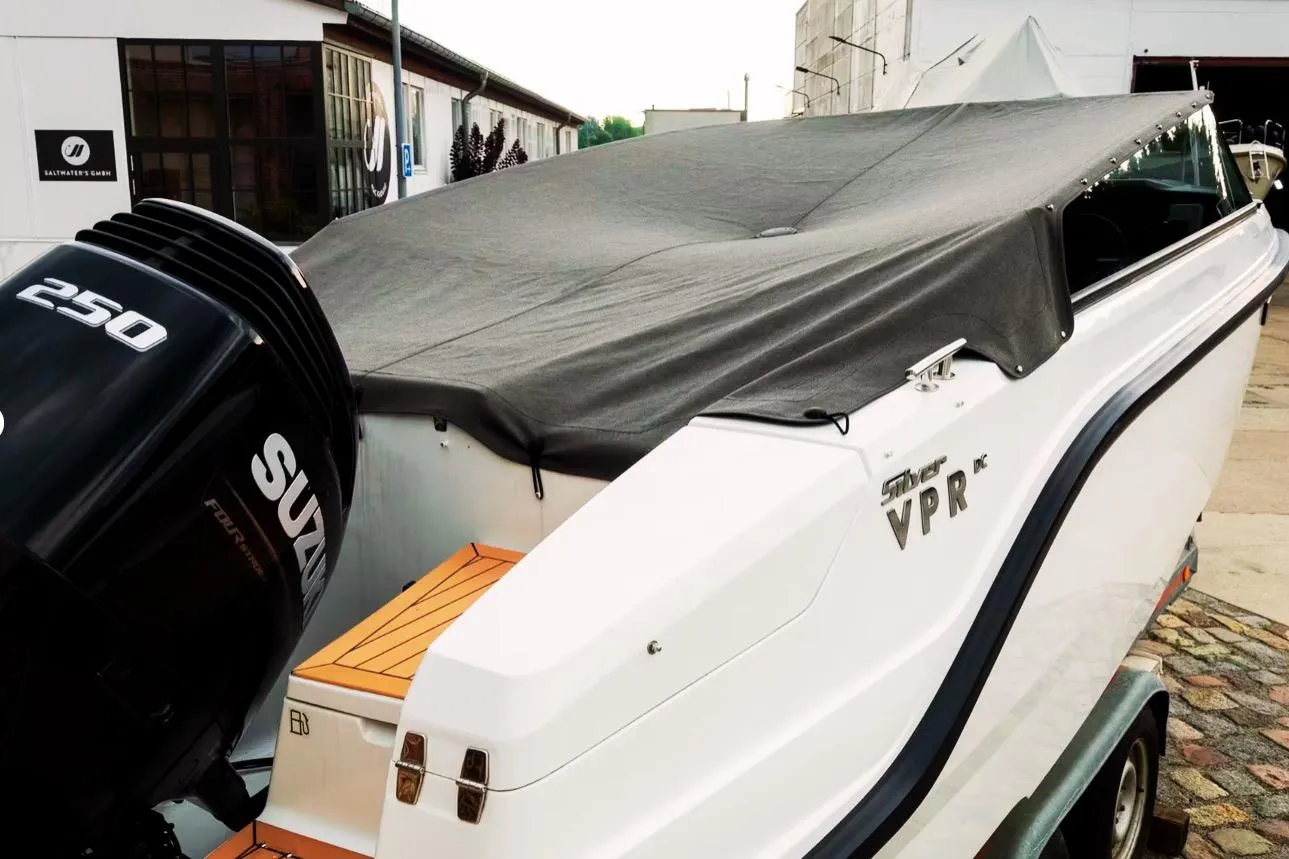 2025 Silver VPR DCZ boat with Suzuki 250 engine, covered and parked outdoors.