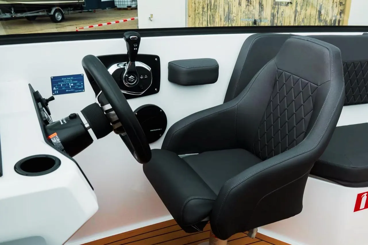 Interior of 2025 Silver VPR DCZ boat with steering wheel and black seat.