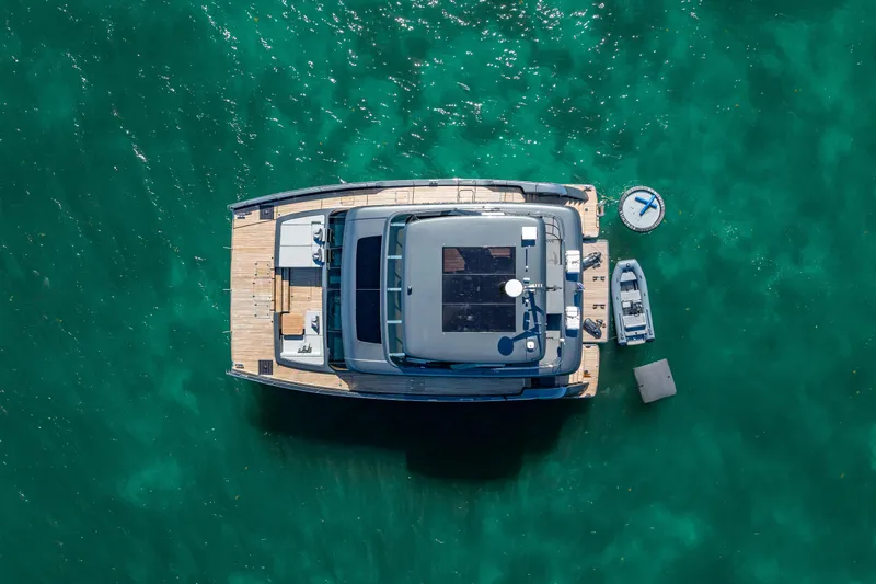 Skip The Wait Yacht Photos Pics Aerial view of 2026 Sunreef 60 Power yacht on turquoise water.