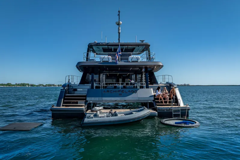 Skip The Wait Yacht Photos Pics 2026 Sunreef 60 Power yacht on water, with people relaxing on the deck.
