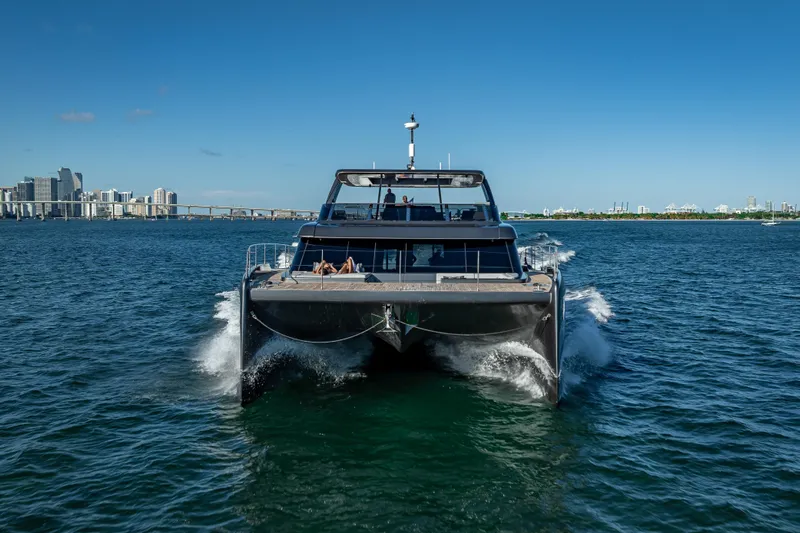 Skip The Wait Yacht Photos Pics 2026 Sunreef 60 Power yacht cruising in open water near city skyline.