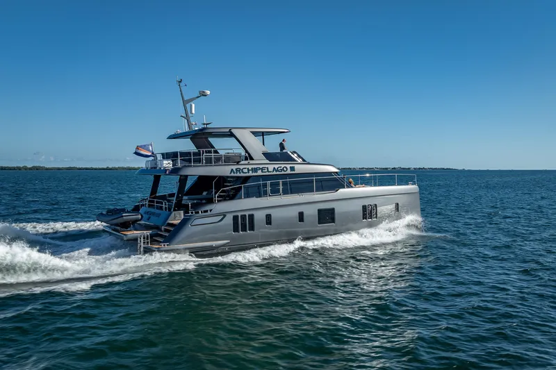 Skip The Wait Yacht Photos Pics Luxurious 2026 Sunreef 60 Power yacht cruising on open water under clear blue skies.