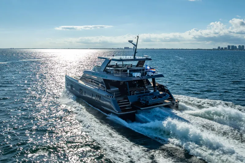 Skip The Wait Yacht Photos Pics Luxurious 2026 Sunreef 60 Power yacht cruising on open sea under clear sky.