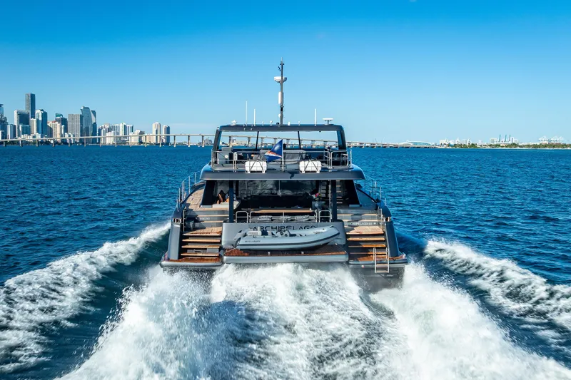 Skip The Wait Yacht Photos Pics 2026 Sunreef 60 Power yacht cruising near city skyline on a sunny day.