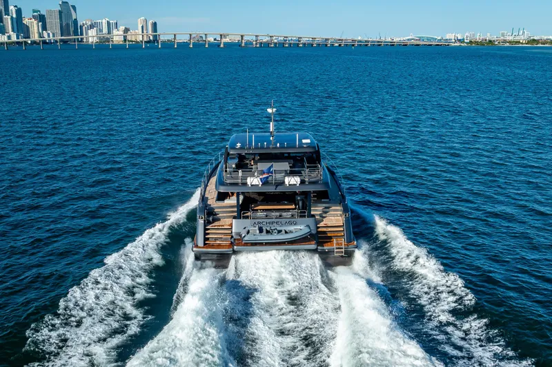 Skip The Wait Yacht Photos Pics Luxurious 2026 Sunreef 60 Power yacht cruising near city skyline.