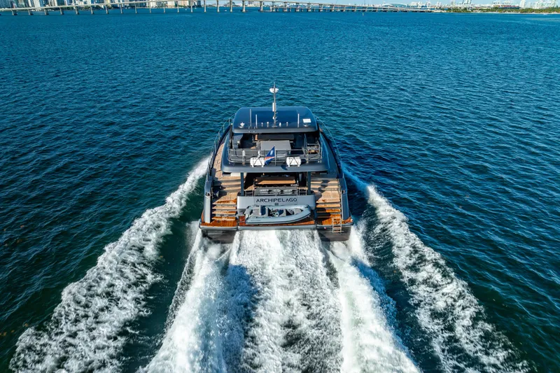 Skip The Wait Yacht Photos Pics 2026 Sunreef 60 Power yacht cruising on open water, cityscape in background.