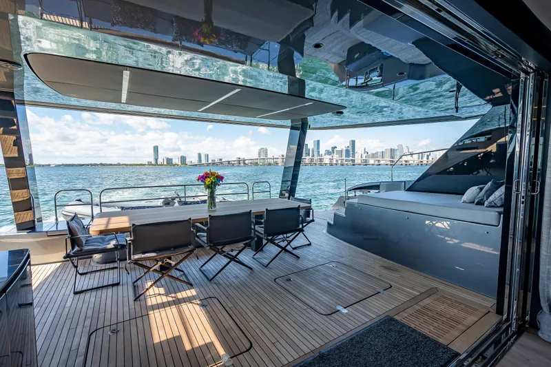 Skip The Wait Yacht Photos Pics Luxurious Sunreef 60 Power yacht interior with city skyline view, featuring elegant seating and dining area.