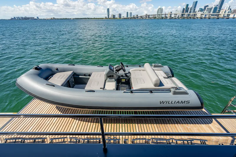 Skip The Wait Yacht Photos Pics RIB boat on Sunreef 60 Power yacht deck, city skyline in background, 2026 model.