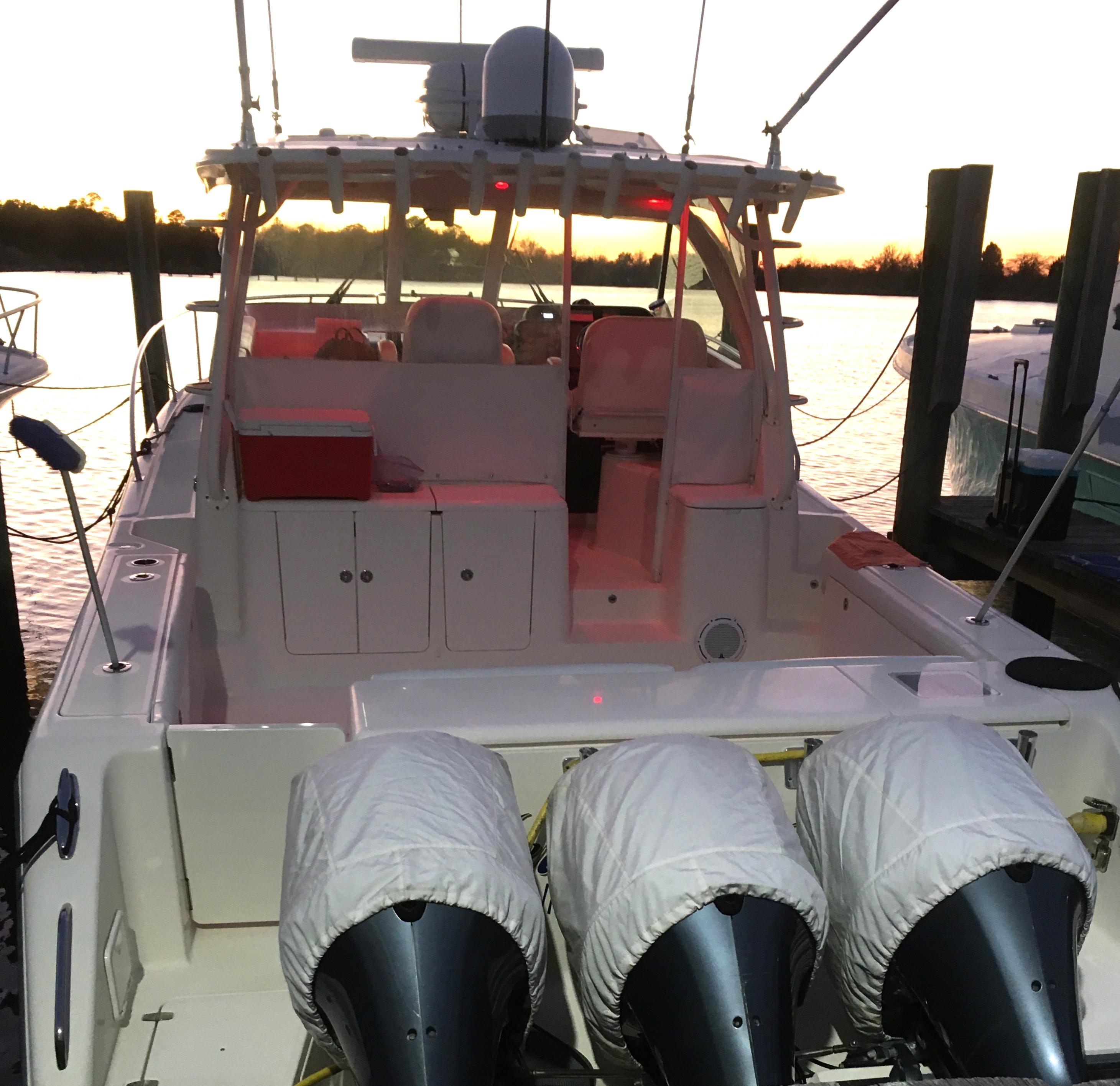 2013 Pursuit OS 385 Offshore boat docked at sunset.