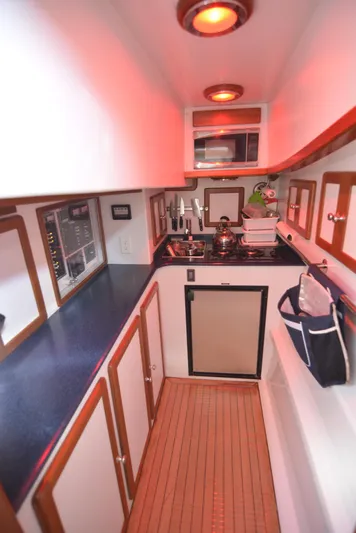 Blue Marble Explorer Yacht Photos Pics Compact kitchen area in a 2005 Custom P-38 Lightning Power Catamaran with red lighting.