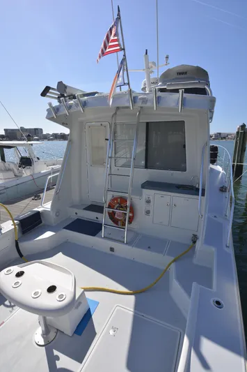 Blue Marble Explorer Yacht Photos Pics Custom 2005 P-38 Lightning Power Catamaran docked, rear view with ladder and American flag.