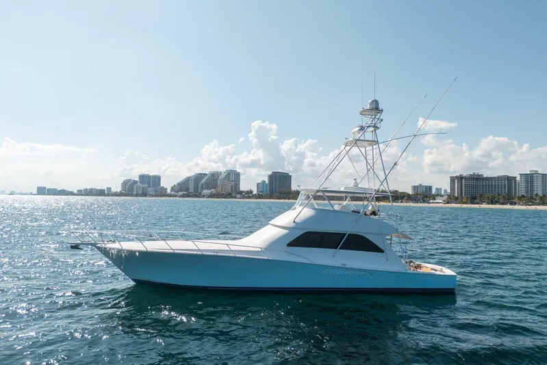 Running Over Yacht Photos Pics 2006 Viking 68 Convertible yacht cruising near a city skyline on a sunny day.
