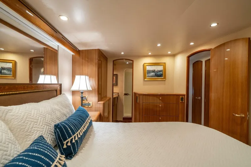 Running Over Yacht Photos Pics Luxurious bedroom interior of 2006 Viking 68 Convertible yacht with elegant wood finishes.