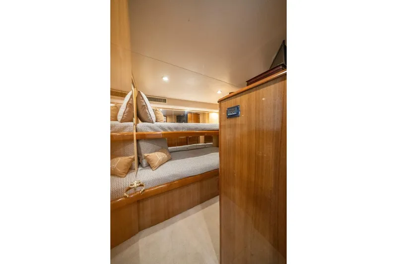 Running Over Yacht Photos Pics Interior of 2006 Viking 68 Convertible yacht with cozy bunk beds and wooden finish.