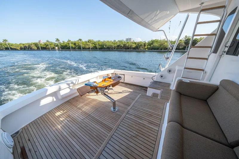 Running Over Yacht Photos Pics 2006 Viking 68 Convertible yacht deck with seating, table, and ocean view.