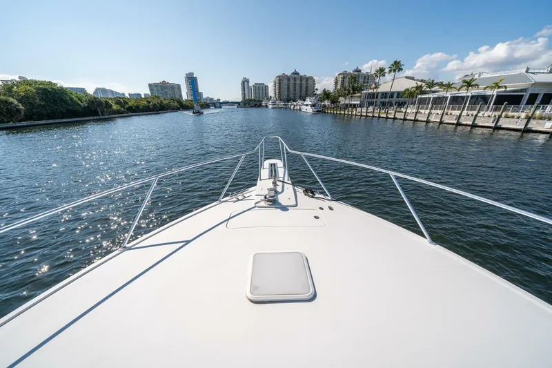 Running Over Yacht Photos Pics Bow view of 2006 Viking 68 Convertible yacht cruising in a sunny urban waterway.