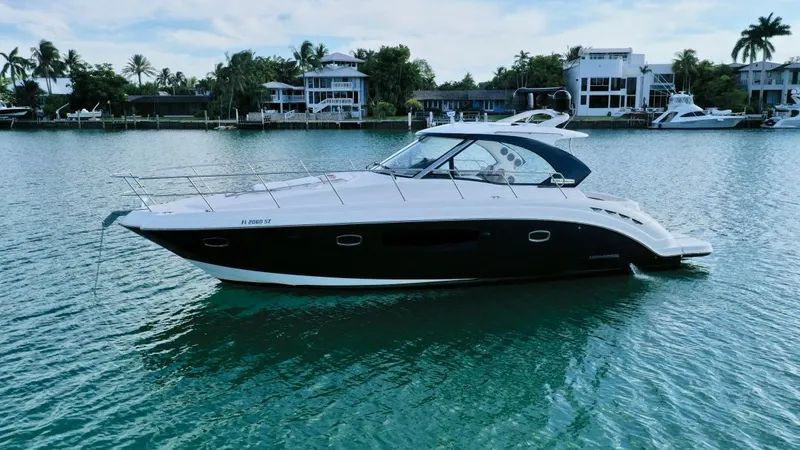  Yacht Photos Pics Chaparral Premiere 400 yacht, 2010 model, on calm water with luxury homes in the background.