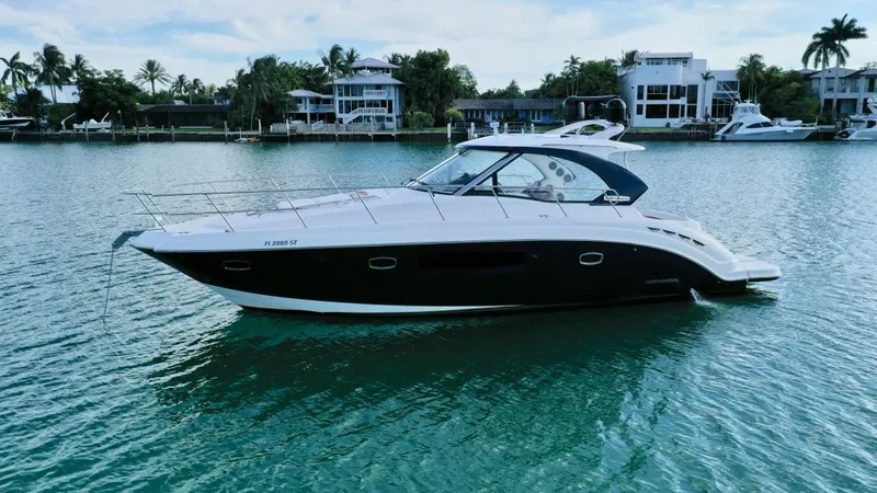  Yacht Photos Pics Chaparral Premiere 400 yacht, 2010 model, cruising on a serene waterfront with luxury homes.